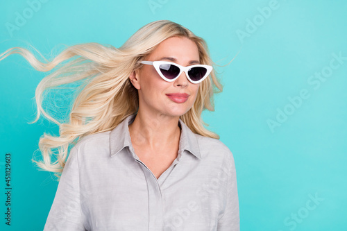Profile photo of sincere positive lovely lady look empty space wear sunglass grey shirt isolated teal color background © deagreez