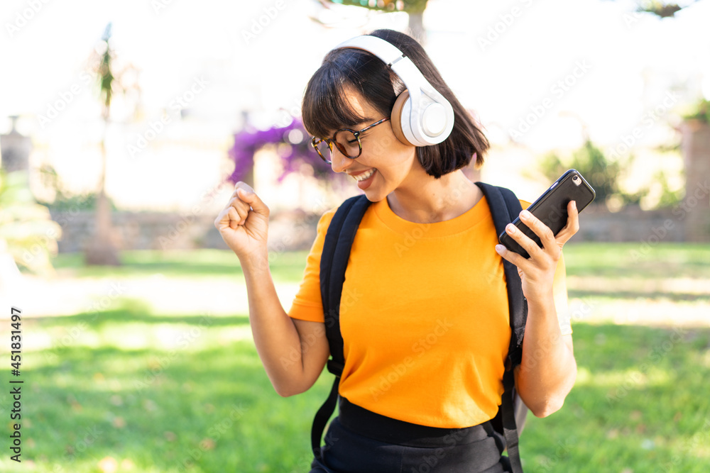 Young student woman in a park using mobile phone Young student woman in a park using mobile phone