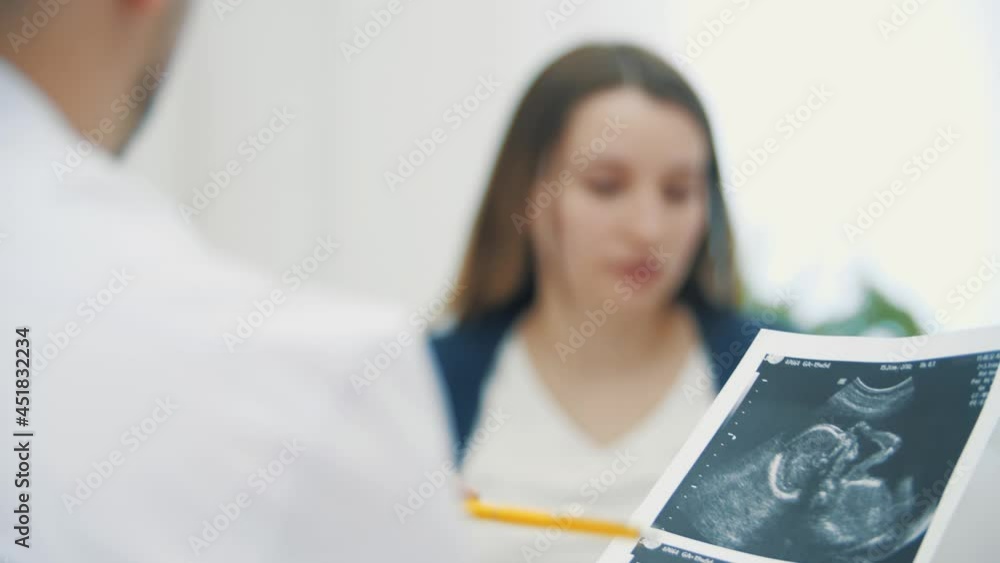 4k video of blurred motion of pregnant woman and doctor showing ultrasound results. 4k video of blurred motion of pregnant woman and doctor showing ultrasound results.