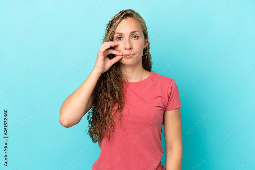 Young caucasian woman isolated on blue background showing a sign of silence gesture Young caucasian woman isolated on blue background showing a sign of silence gesture