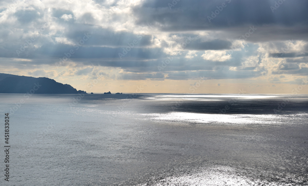 Sun rays, clouds and shores of the Cantabrian Sea in Spain