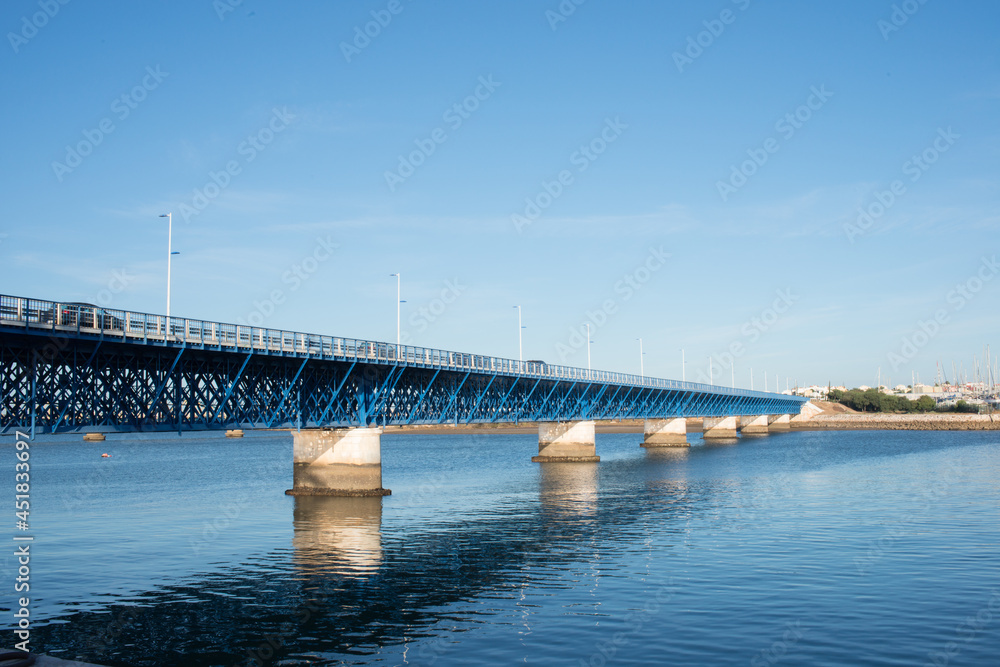 Obraz premium Beautiful old blue bridge over Arade river at Portimao. Cars crossing, Portugal, Europe