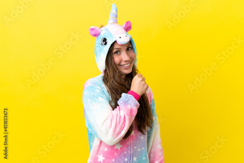 Girl with unicorn pajamas over isolated background celebrating a victory