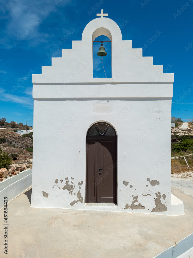 Whitewashed chapel and belfry at Kimolos island Cyclades Greece. Vertical