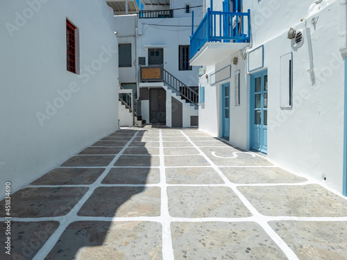 Cobblestone street whitewashed buildings Mykonos island Cyclades Greece.