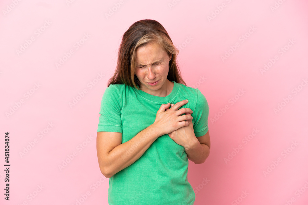 Young English woman isolated on pink background having a pain in the heart Young English woman isolated on pink background having a pain in the heart