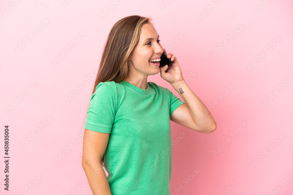 Young English woman isolated on pink background keeping a conversation with the mobile phone Young English woman isolated on pink background keeping a conversation with the mobile phone