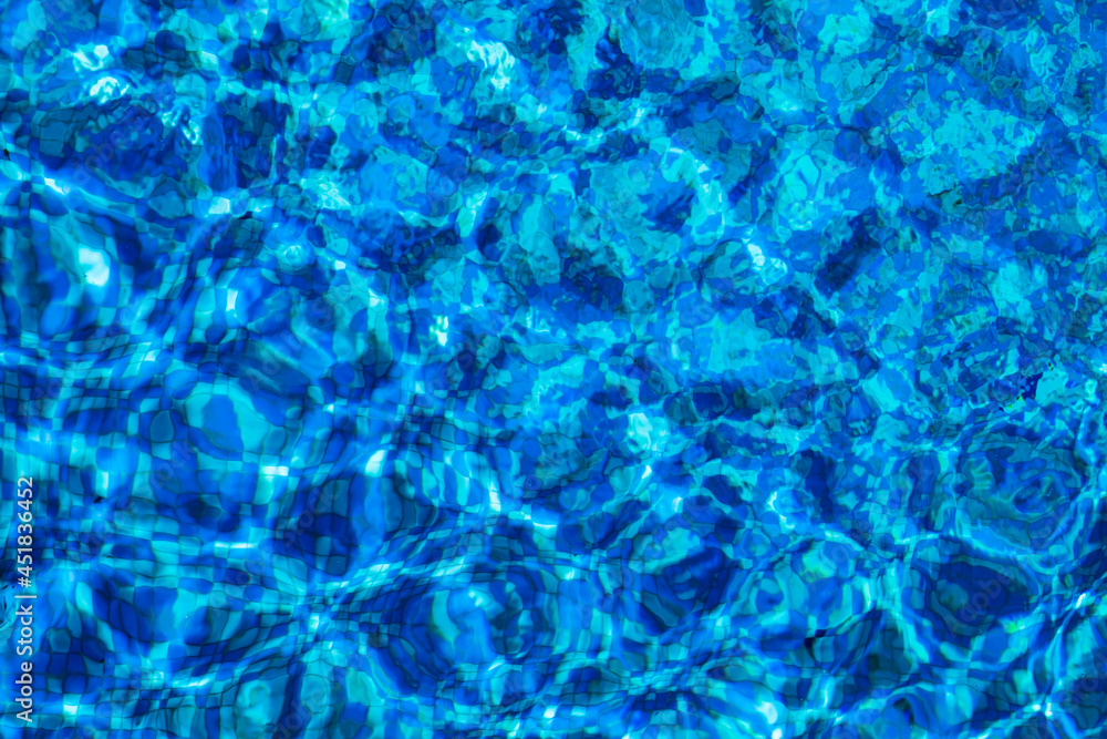 Solar glare on the water in the pool. Blue surface water background Solar glare on the water in the pool. Blue surface water background