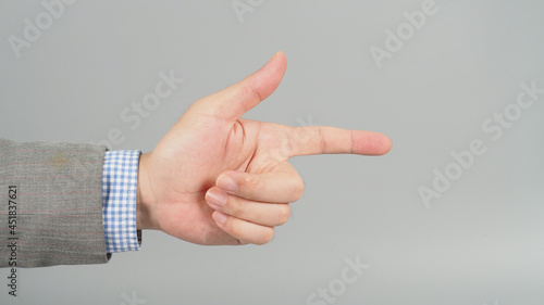 Hand is pointing gesture in grey suit on grey background. Businessman topic. photo