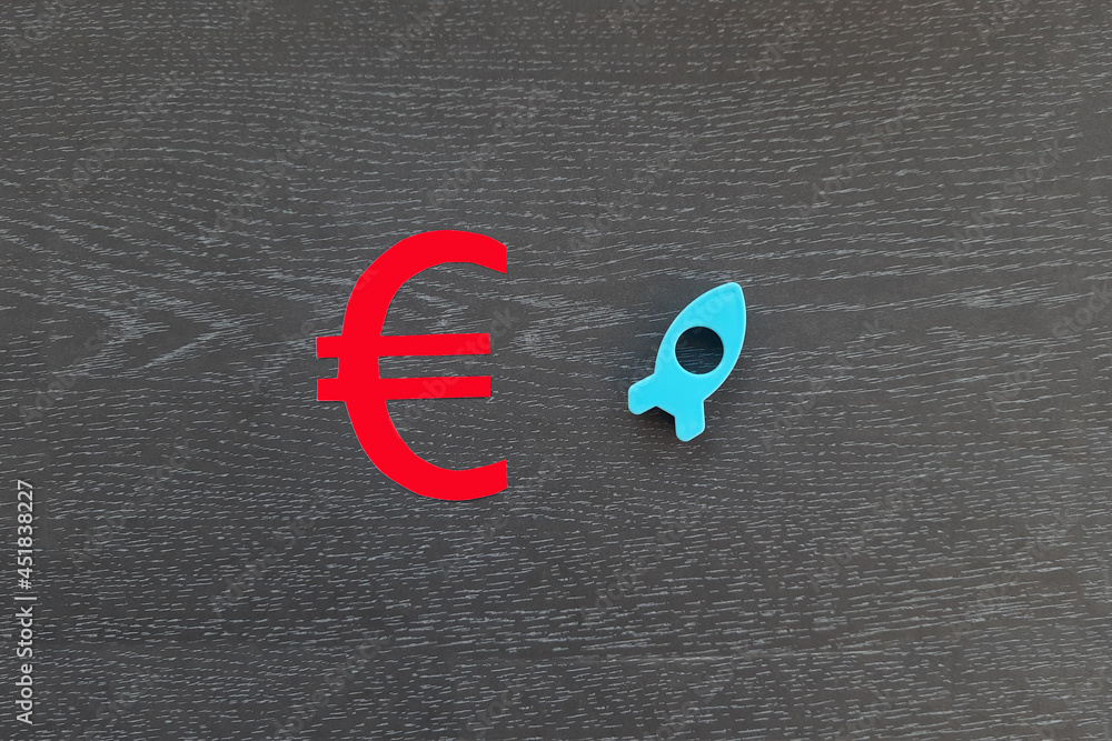 The euro sign is red. a rocket flying up is blue on a dark background. The concept of financial cash growth.