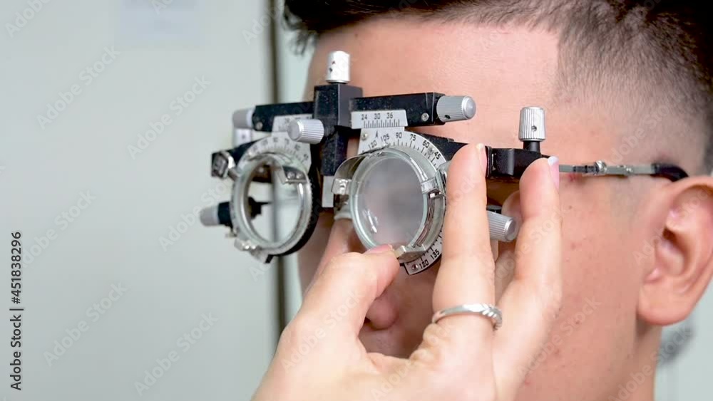 hombre joven con lentes de prueba en examen de la vista 
