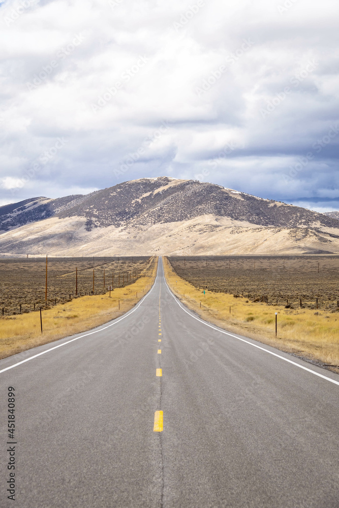 A long, straight road heading into the distant mountains A long, straight road heading into the distant mountains