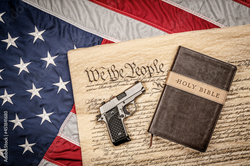 Holy bible and gun on constitution and American Flag photo