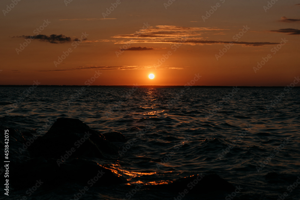 Naklejka premium Photo of a Summer Sunset on the Lake. Travel location of popular tourist outdoor. View of beautiful Sea Landscape. Relax vacation near water