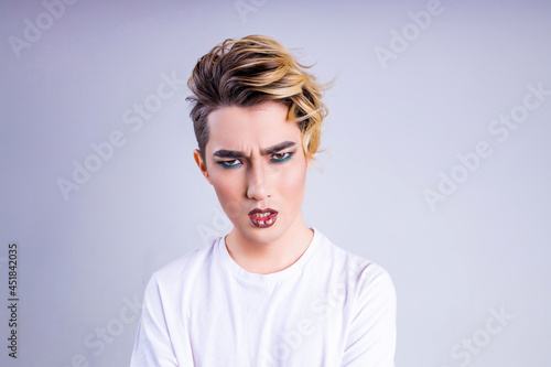 confused wonder asian man with luxurious blonde hair and gorgeous make-up in white wall studio background photo