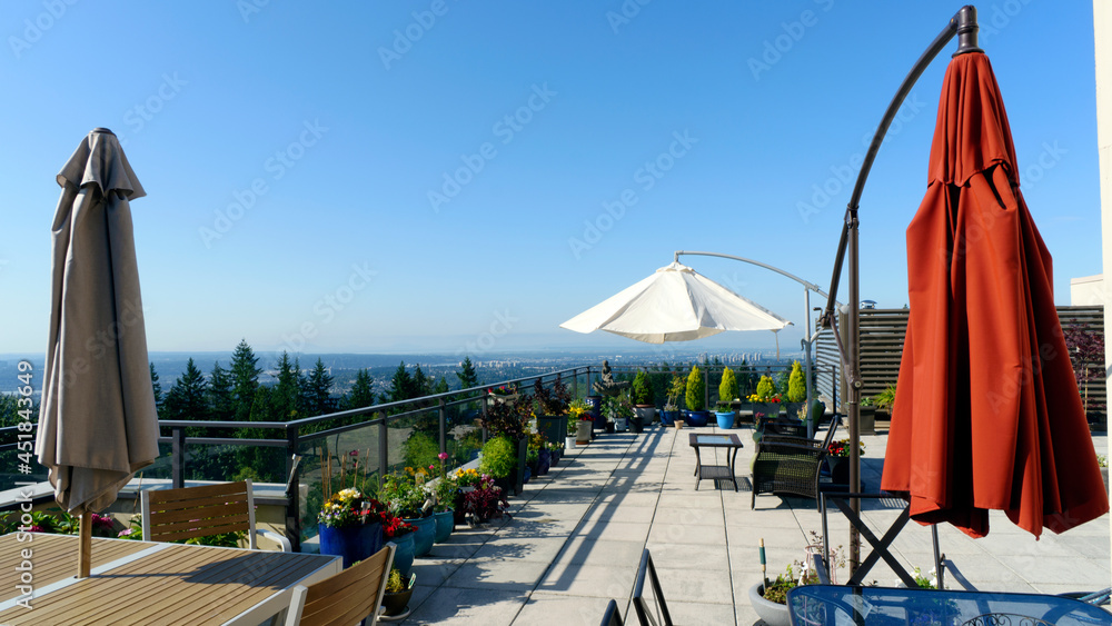 Umbrellas on Burnaby Mountain rooftop patio garden with extensive views.