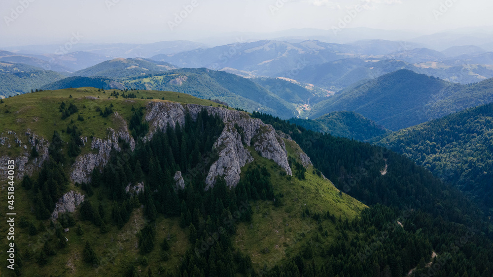 Aerial view of mountains covered with coniferous forests. Aerial beautiful dramatic cloudy sky with mountain view during sunset, Kopaonik, Serbia.