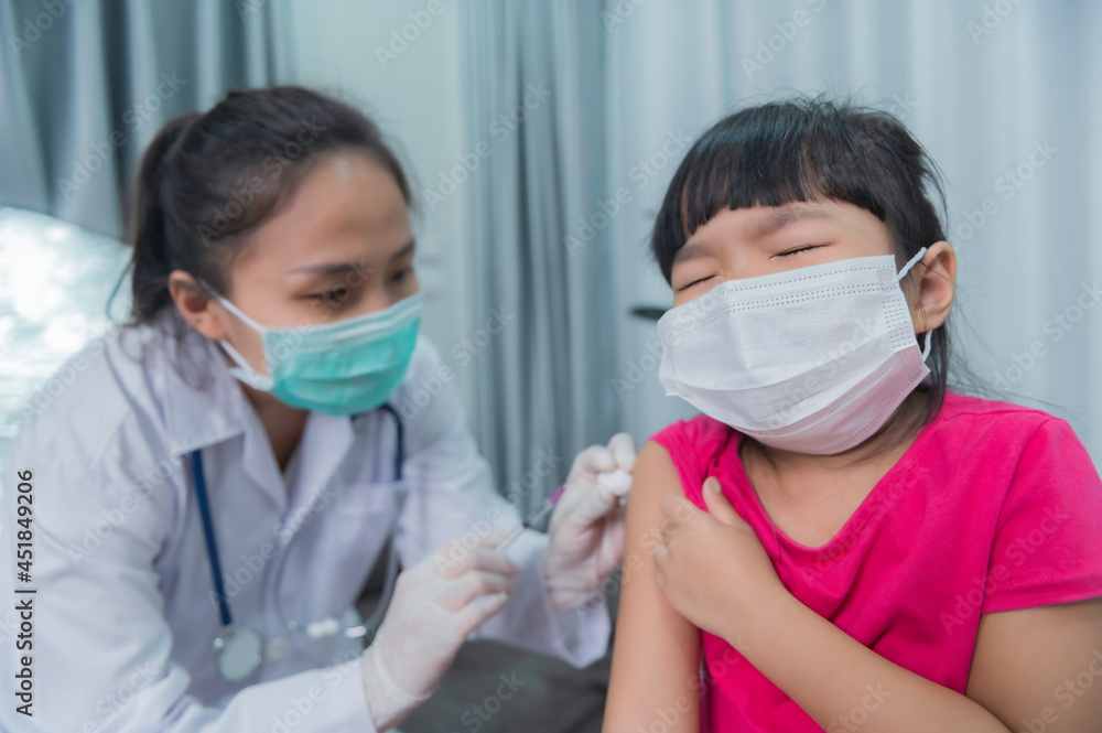 Asian doctor injection vaccine for protecting virus covid-19 to a girl wear medical mask,People are Girls are vaccinated against influenza every year.