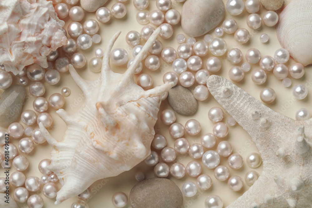 Beautiful sea shells, starfish, pebbles and pearls on beige background, flat lay Beautiful sea shells, starfish, pebbles and pearls on beige background, flat lay