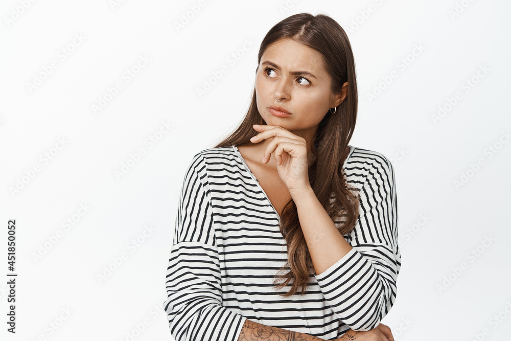 Image of concerned woman thinking, looking at upper left logo with serious, frowned face, white background Image of concerned woman thinking, looking at upper left logo with serious, frowned face, white background