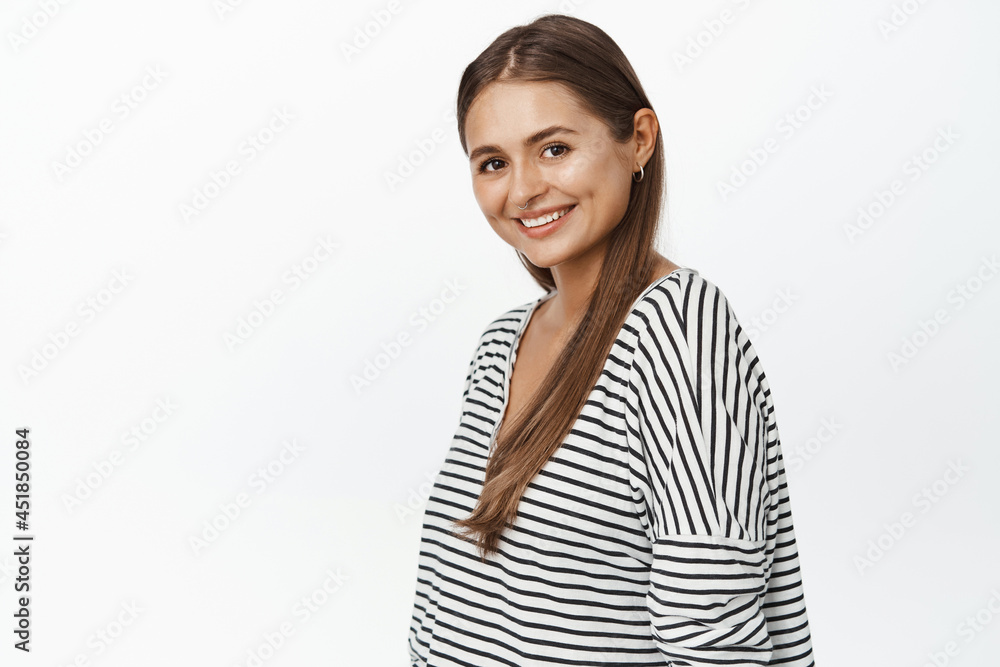 Portrait of young brunette woman in casual clothes, turn face at camera with confident smiling face expression, white background Portrait of young brunette woman in casual clothes, turn face at camera with confident smiling face expression, white background