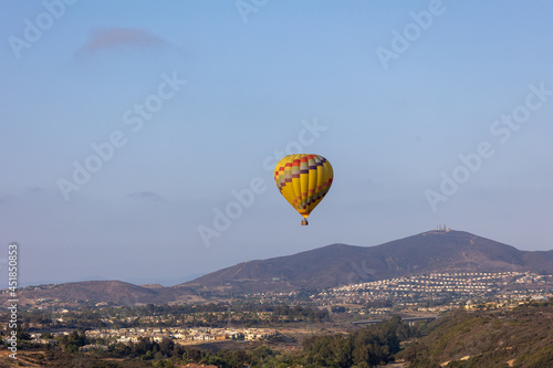 Colorful yellow and red hot air balloons over blue sky in California
