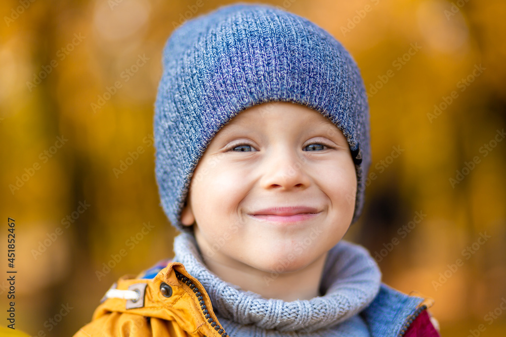 Happy child playing with fallen yellow leaves on a walk in the autumn in the park Happy child playing with fallen yellow leaves on a walk in the autumn in the park