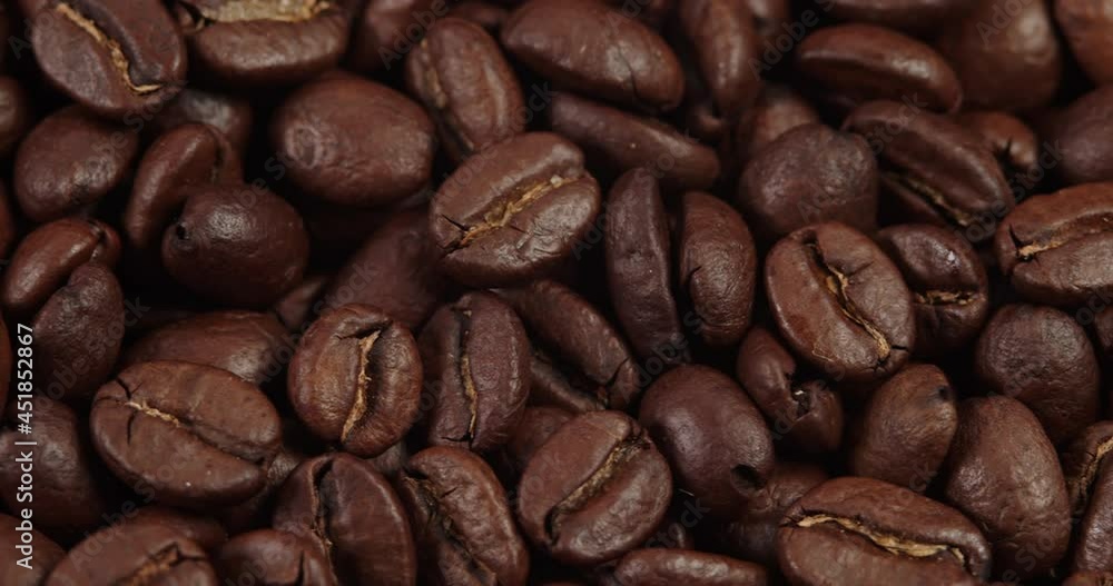 Roasted coffee beans dolly shot. Aromatic coffee beans move slowly. Slide slow motion close-up of whole roasted coffee beans. Roasted coffee beans dolly shot. Aromatic coffee beans move slowly. Slide slow motion close-up of whole roasted coffee beans.