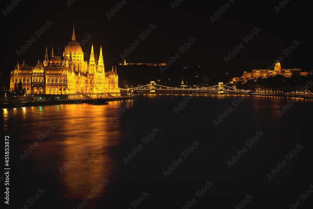 Hungarian Parliament Building located at the bank of Dunabe river with famous Chain Bridge connecting Buda and Pest in Budapest, Hungary