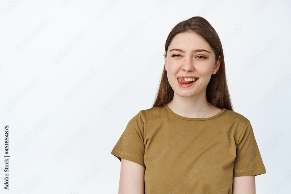 Dental clinic and stomatology concept. Happy young woman showing her white teeth and tongue, smiling at camera, white background Dental clinic and stomatology concept. Happy young woman showing her white teeth and tongue, smiling at camera, white background