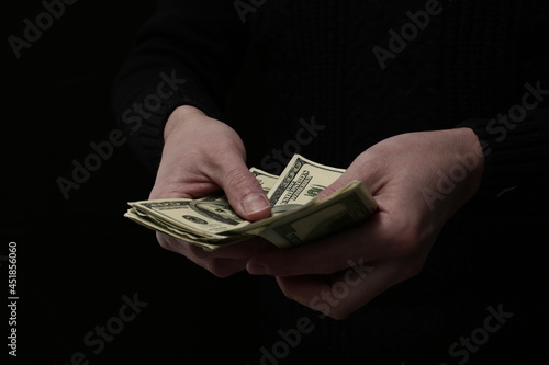 There is a large number of hundred dollar bills in human hands.