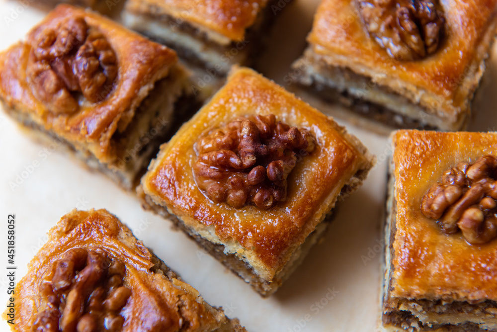 pieces of baklava with walnuts on baking paper with a central composition. pieces of baklava with walnuts on baking paper with a central composition.