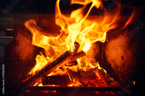 A fire burns in a fireplace  Fire to keep warm. Logs burning in a fireplace