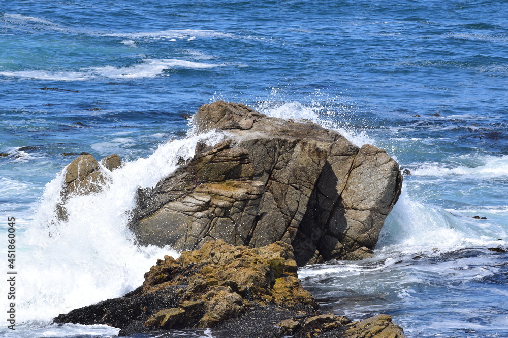Ocean waves splashing onto some rocks at 17 Mile Drive in Monterey, California.