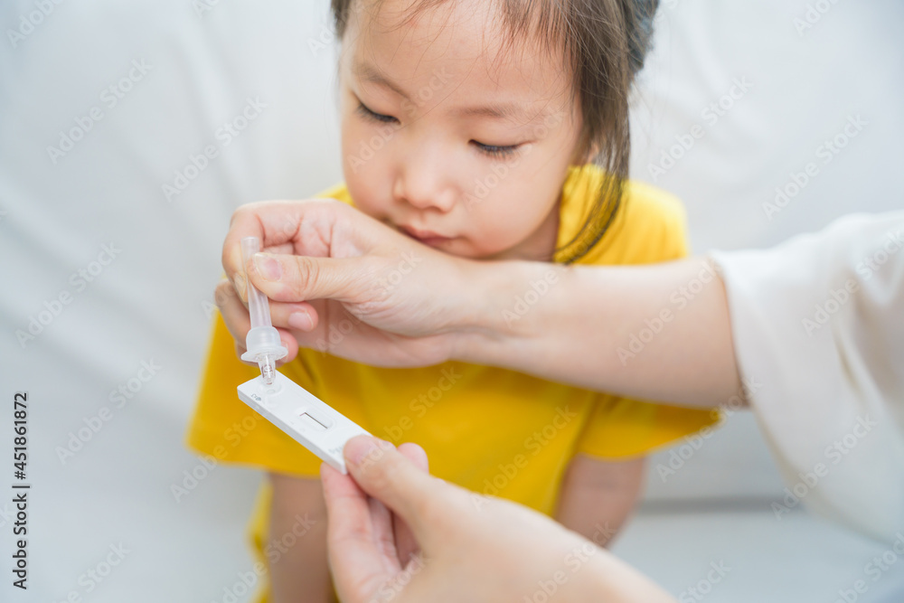 Adorable Asian girl kid pay attention with swab test process by her parent. Rapid self test for covid-19, Antigen test kit, quick check before school. new normal routine for kid. Selective focused. Adorable Asian girl kid pay attention with swab test process by her parent. Rapid self test for covid-19, Antigen test kit, quick check before school. new normal routine for kid. Selective focused.