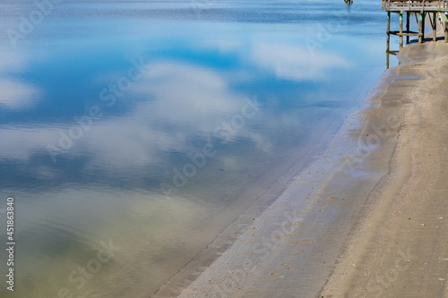 Fototapeta Naklejka Na Ścianę i Meble -  Blue sky and clouds reflected in still bay waters, Tybee Island Georgia USA, horizontal aspect