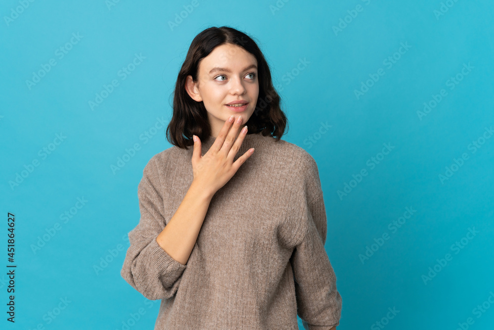 Teenager Ukrainian girl isolated on blue background looking up while smiling Teenager Ukrainian girl isolated on blue background looking up while smiling