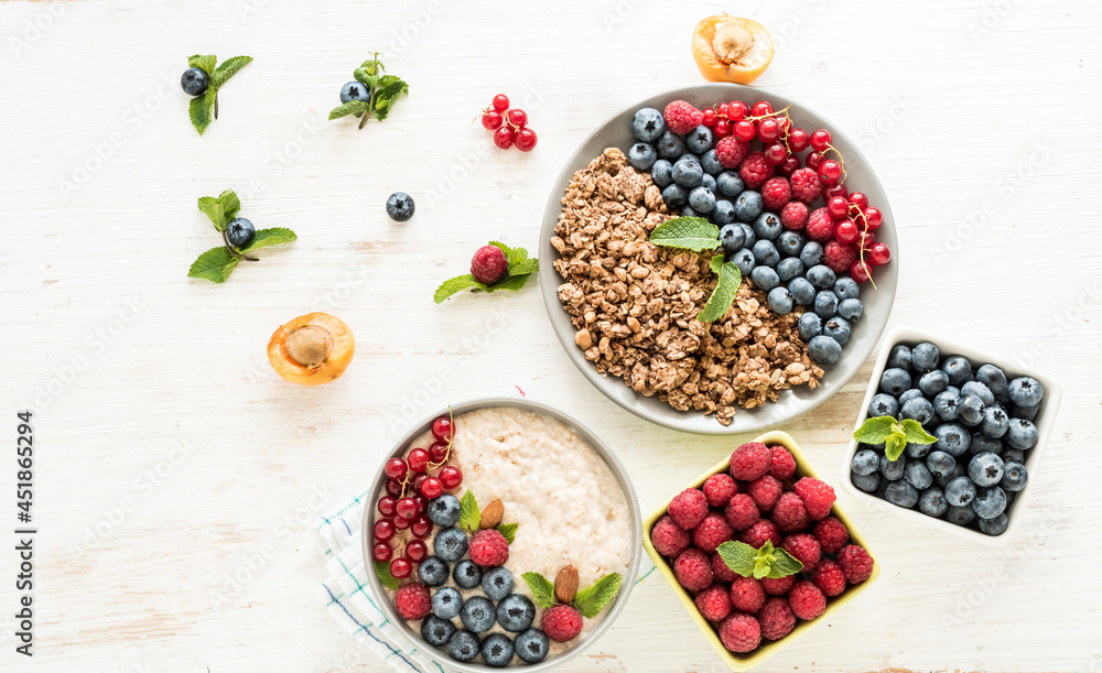 An energetic, delicious breakfast in the morning with granola, oatmeal with fruits and berries. Flat layouts for healthy food