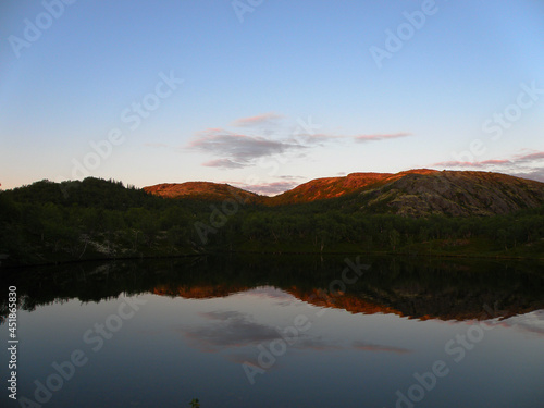 Summer beautiful forest and blue mountain lake against the backdrop of mountains chooses a polar day. The time when the sun always shines is a polar day, Murmansk.