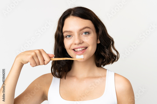 Teenager Ukrainian girl isolated on white background with a toothbrush and happy expression