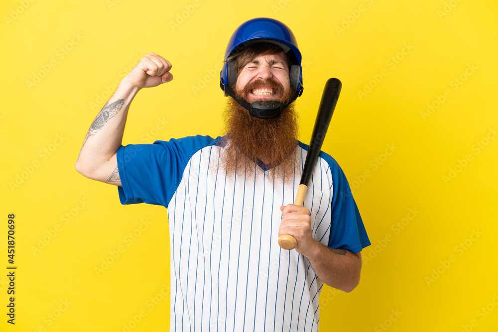 Redhead baseball player man with helmet and bat isolated on yellow background doing strong gesture Redhead baseball player man with helmet and bat isolated on yellow background doing strong gesture