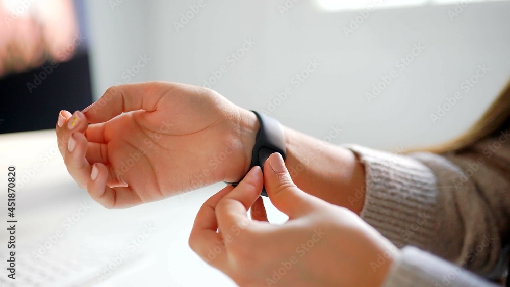 Hands of a woman who is putting on a watch
