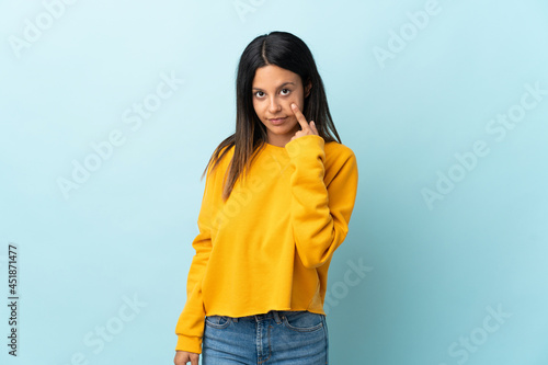 Caucasian girl isolated on blue background showing something