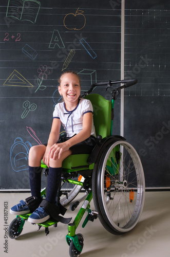 Special child on wheelchair. Girl in school uniform on the background of the school board.