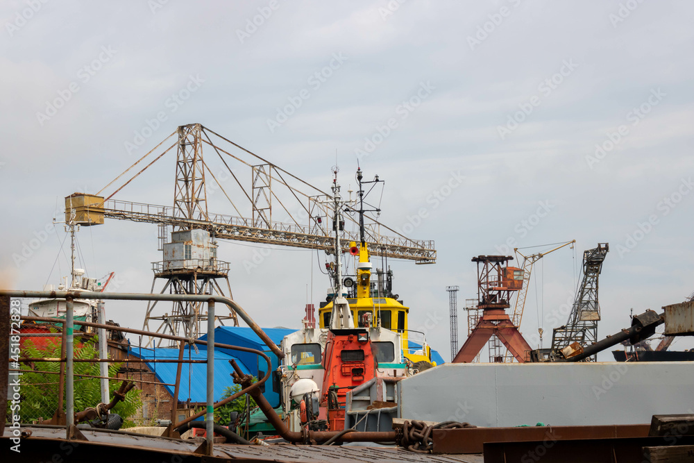 Old rusty cranes and steamers in the port