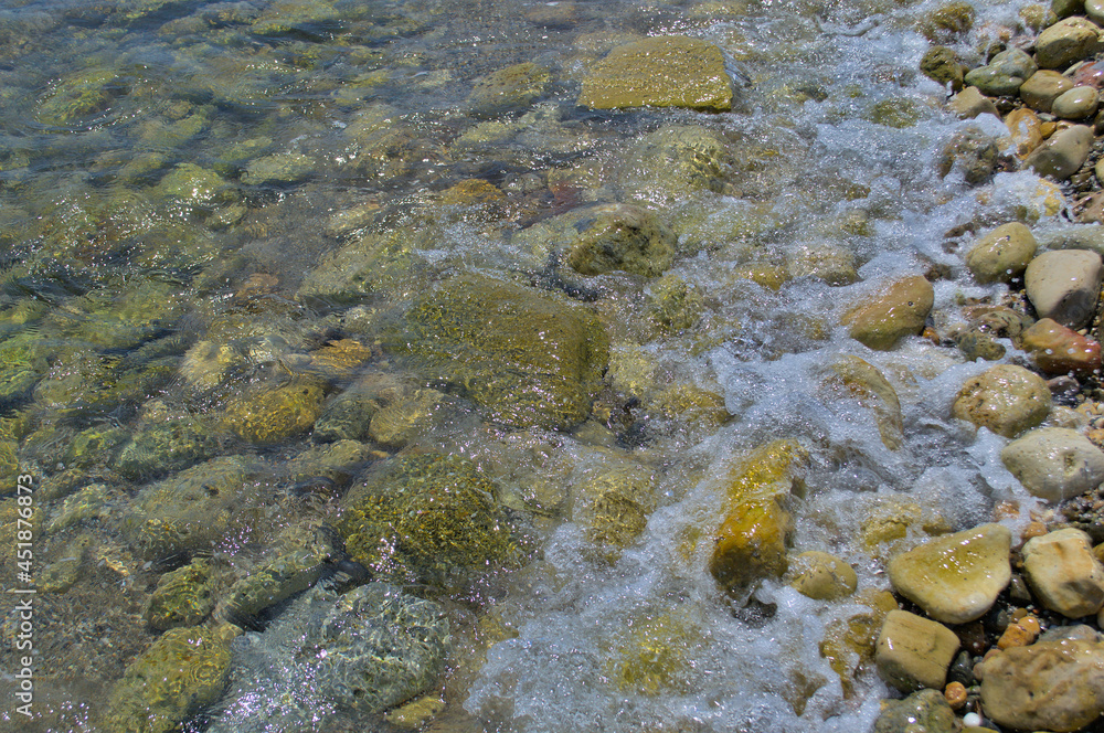 Waves hit the rocks near the beach.