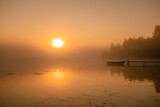 Scenic misty Sunrise over lake with large orange Sun, reflection. Copy space