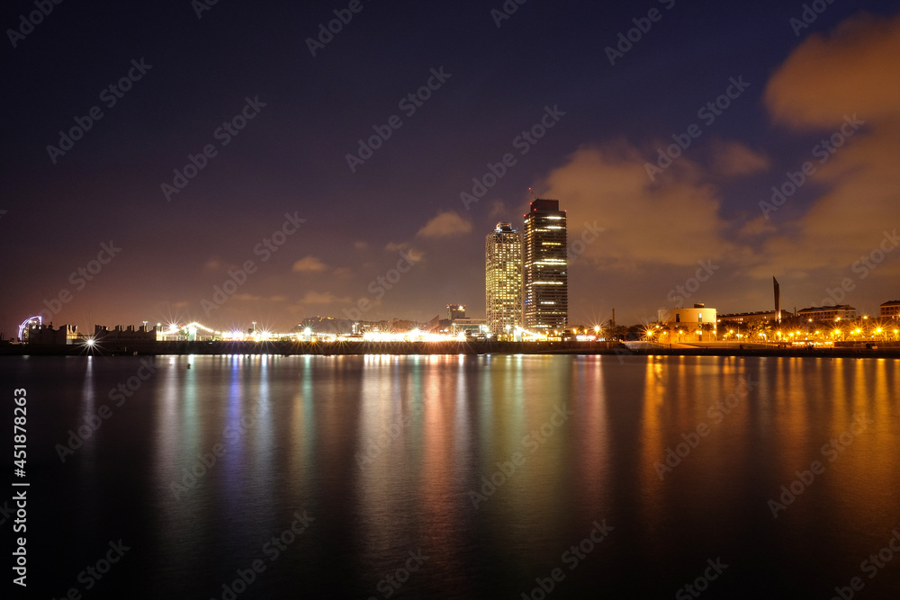 Barcelona, ​​views of the city, the sea and the mapfre tower. Skyscrapers of the Paseo Maritimo illuminated at night in Barcelona, ​​Catalonia, Spain