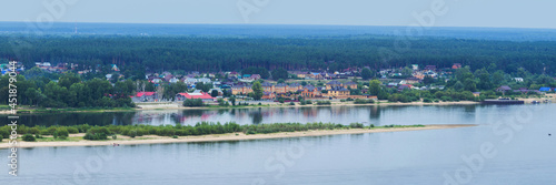 Kokshaysk, Russia - August, 09 2021: Panoramic view of the village of Kokshaisk from the opposite high shore of the Volga River