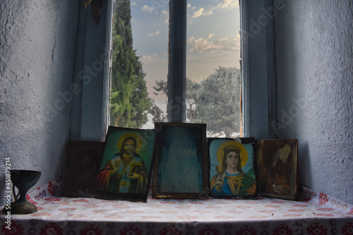 Obraz na plátně religious icons in the window of the chapel and trees in the sky in the back